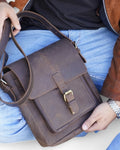 Front buckle closure detail on women's leather satchel