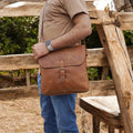 Leather satchel displayed with everyday essentials – Perfectly fits an iPad, phone, wallet, and notebook.
