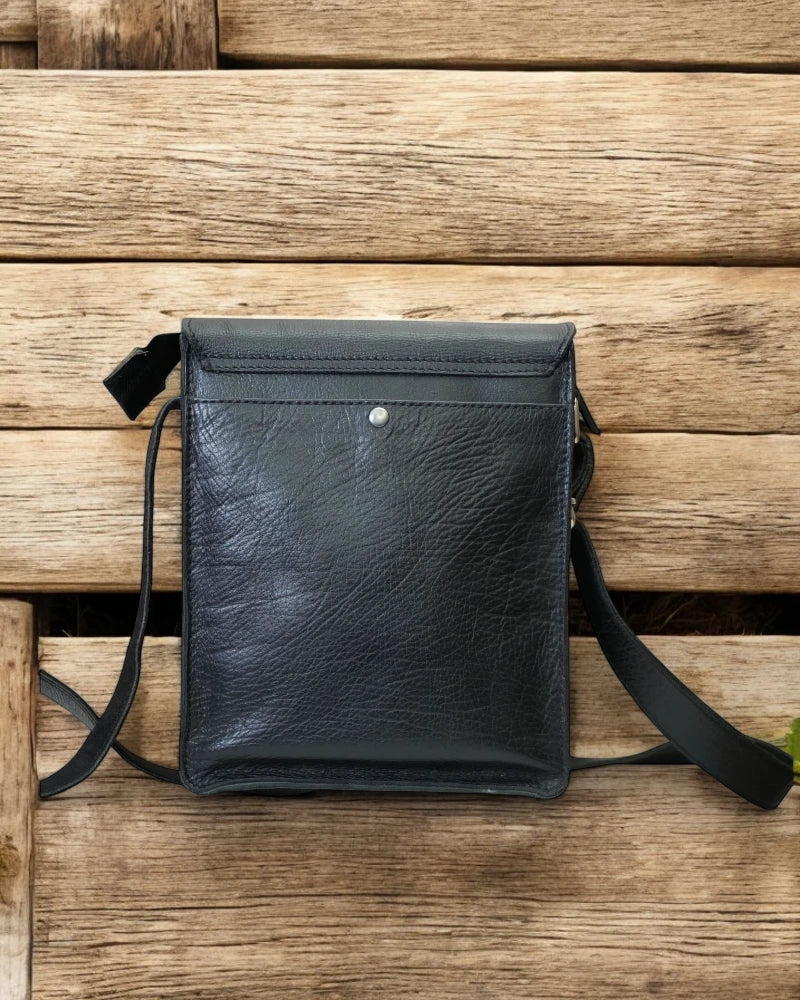 Spacious interior of a black leather messenger bag with compartments