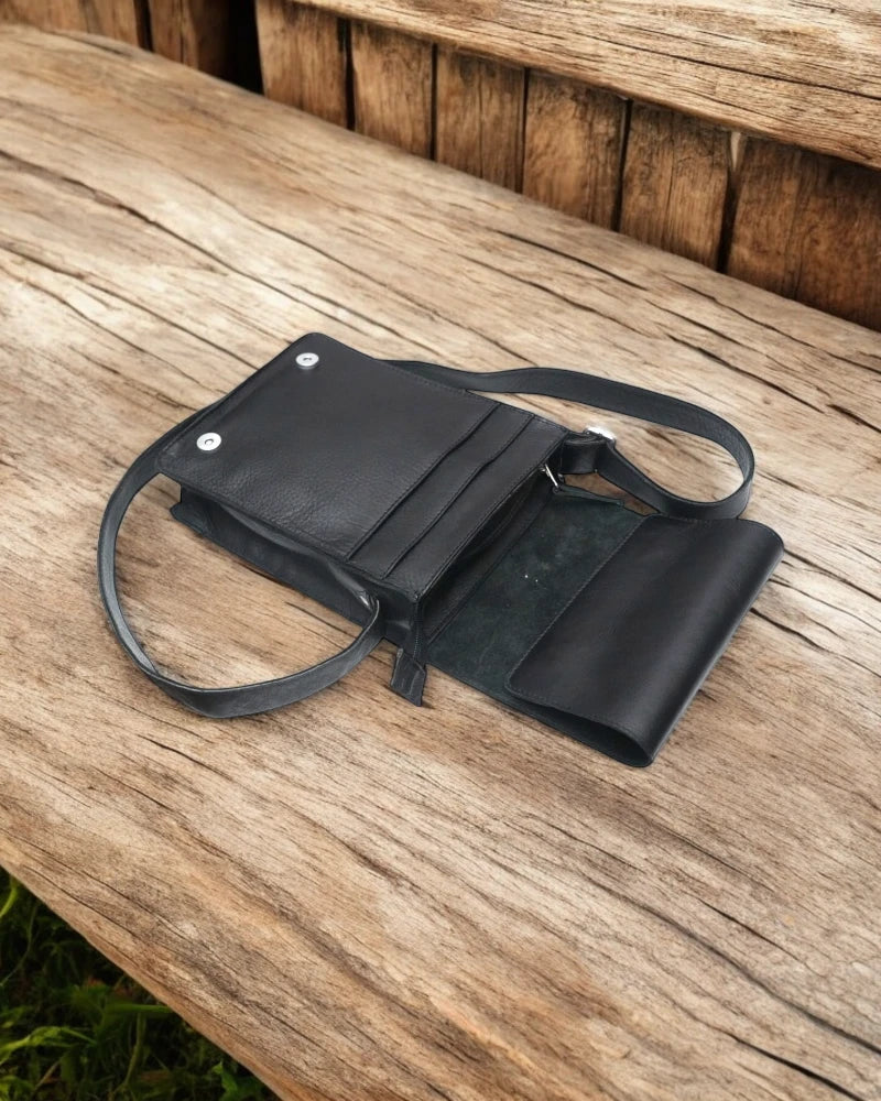 Black leather messenger bag with laptop and essentials inside
