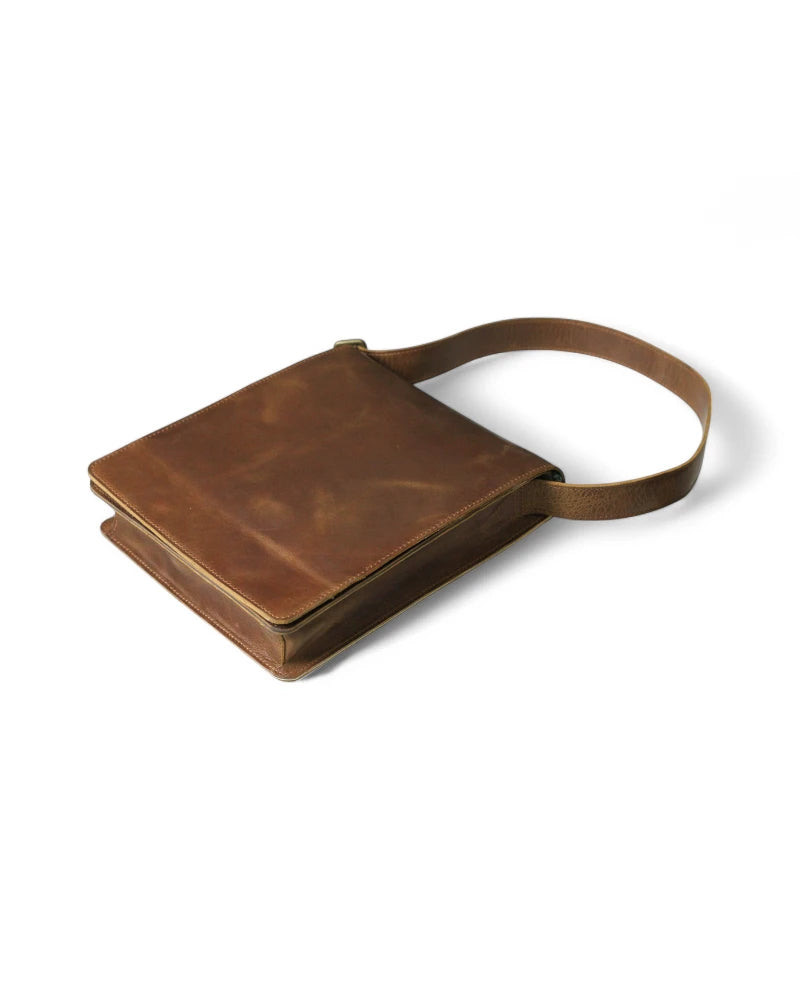 Durable metal hardware and clasps on a brown leather messenger bag